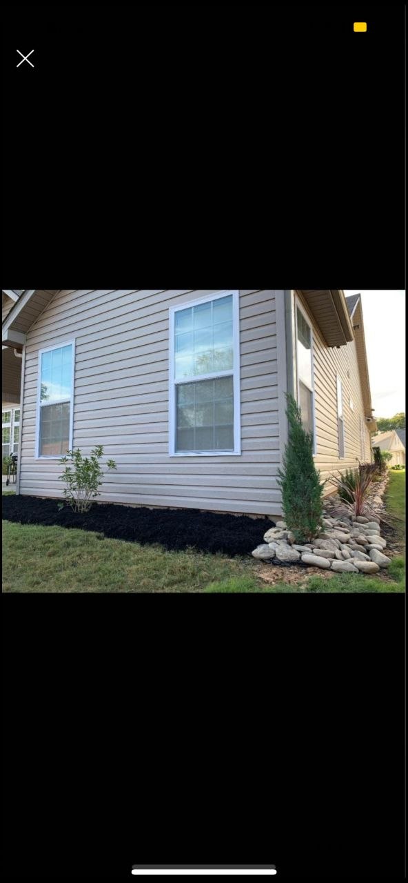 Fresh black mulch and river rock border with juniper — Redwood Landscaping hardscaping SC